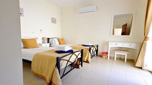 A hotel room with two beds, a desk, and a chair. - Villa Jasmin (Coral Bay)