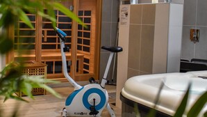 A bathroom with a bathtub, a shower, and a toilet. There is a wooden door and a window with blinds. - GITE NOLAN *** SPA/SAUNA, 20MN FROM PUY DU FOU, IDEAL WITH FAMILY OR FRIENDS (Saint-Mesmin)
