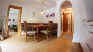A dining area with a wooden table and chairs, a cross on the wall, and a painting above the table. - Quiet in the center: apartments The ideal basis for outdoor activities (Oetz)