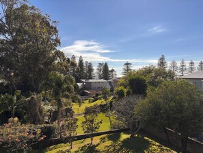 A residential area with houses, a grassy lawn, and trees.