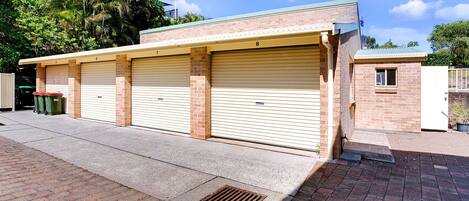 A building with three garage doors, numbered 5, 6, and 7, and a small window on the right.