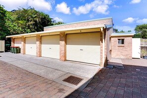 A building with three garage doors, numbered 5, 6, and 7, and a small window on the right.