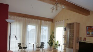 A living room with a sofa, two chairs, a coffee table, a TV, a cabinet, and a plant. - Limburg: TOP apartment 75 sqm with balcony in quiet vorz. location (Limburg an der Lahn)