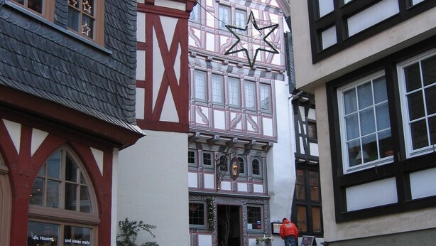 A narrow cobblestone street lined with traditional half-timbered buildings, one with a prominent 'X' sign. - Limburg: TOP apartment 75 sqm with balcony in quiet vorz. location (Limburg an der Lahn)