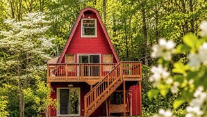 Una casa roja de dos pisos con un balcón y una escalera.