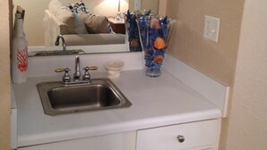 A small kitchenette with a sink, a microwave, and a cabinet. - 1st Floor, Updated, 5 min walk to the beach! (Hilton Head Island)
