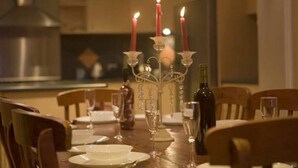 A dining table set for four with candles, wine glasses, and plates. - Stanthorpe Country Resort, 6 bedrooms for 12 guests (Stanthorpe)