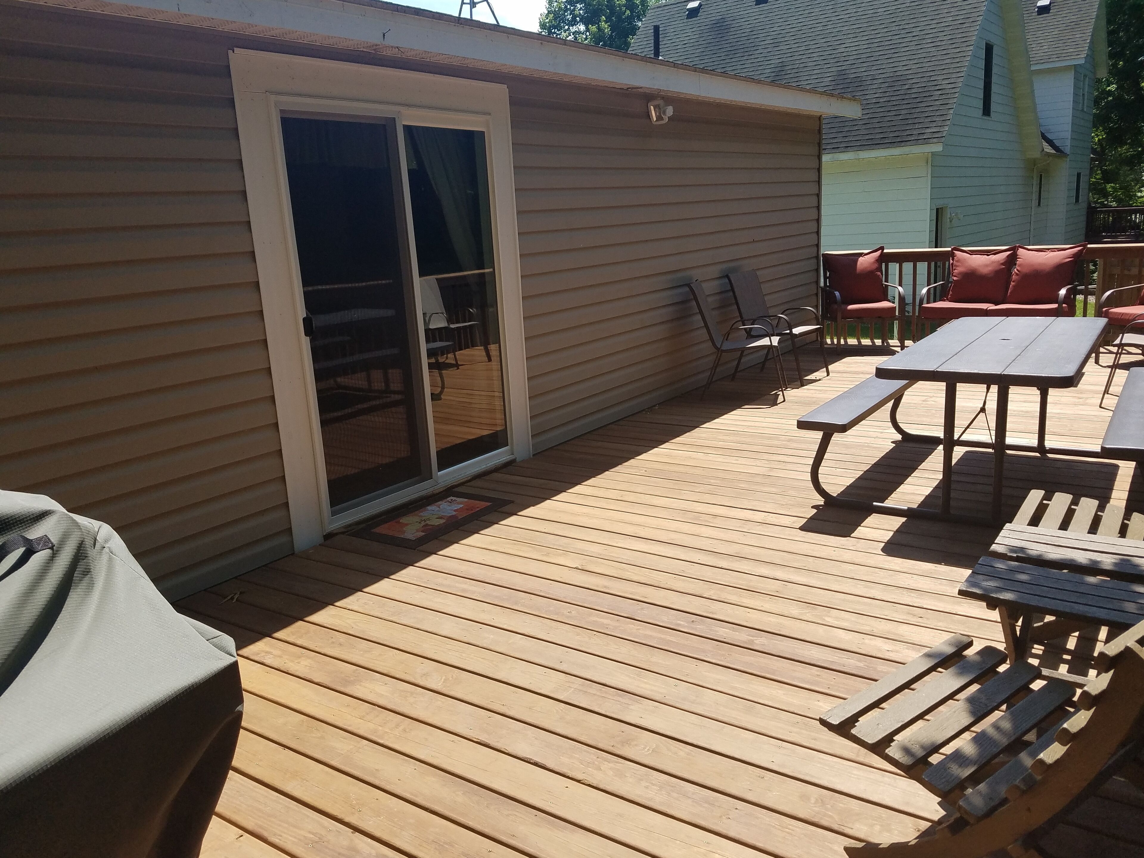 Una terraza de madera con un muro cortina corredizo que da a un patio.