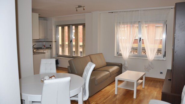 A modern living room with a sofa, a dining table, and a kitchen in the background. - Calle quinta D, Historic Center of Salamanca, new apartment (Salamanque)