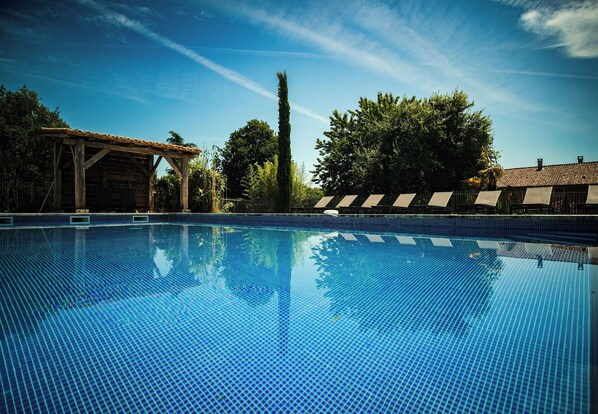 Una piscina al aire libre, una piscina climatizada