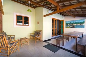 A room with a dining table, chairs, a green hanging light, and a painting on the wall. - House in the center of Paraty with swimming pool. (PARATI)