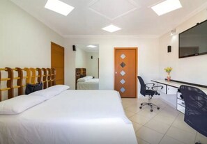 A hotel room with a bed, a desk, a chair, and a television. - House in the center of Paraty with swimming pool. (PARATI)