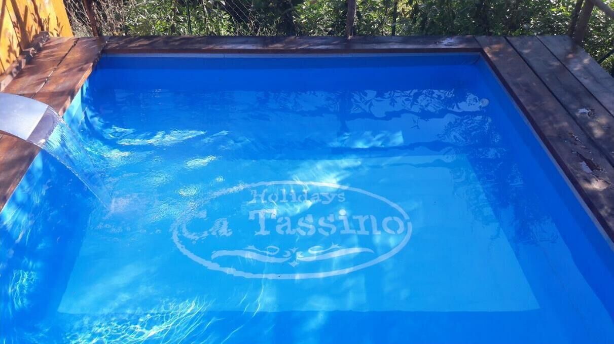 En swimmingpool med en træterrasse og et logo på vandoverfladen.