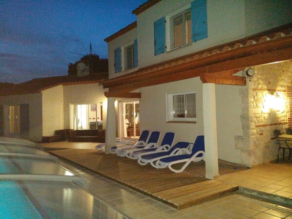 A poolside area with lounge chairs and a pool.