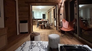 A modern kitchen with marble countertops, a black sink, and a dining area with wooden flooring and a table. - Apt. duplex of 72 m2, 3 bedrooms, in the heart of Alpe d'Huez garden (Huez)
