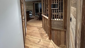 A hallway with wooden flooring and a rustic design, leading to a dining area with a table and chairs. - Apt. duplex of 72 m2, 3 bedrooms, in the heart of Alpe d'Huez garden (Huez)
