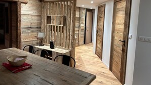 A modern dining area with a wooden table and chairs, a red napkin, and a lamp on the table. - Apt. duplex of 72 m2, 3 bedrooms, in the heart of Alpe d'Huez garden (Huez)