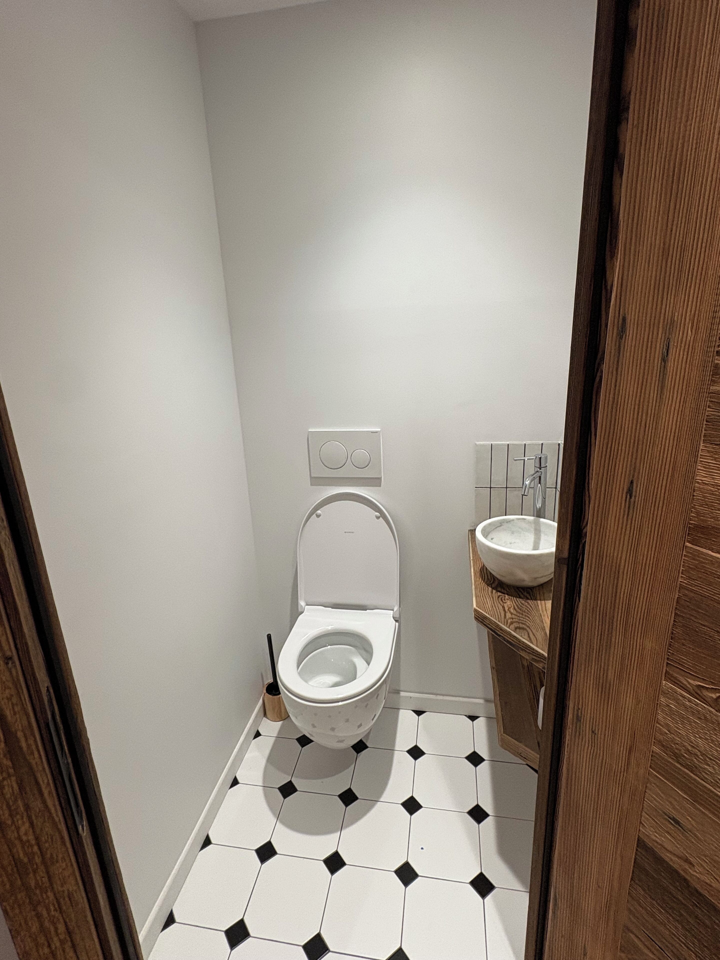 A small bathroom with a toilet, a sink, and a hand dryer.