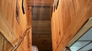 A wooden staircase with a handrail, leading to a room with a window and a ceiling light fixture. - Pet friendly,cozy cabin near Tail of the Dragon.Paved driveway & covered parking (Robbinsville)
