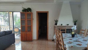 Un coin repas avec une table dressée pour quatre personnes, un buffet en bois et un canapé.