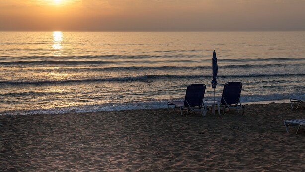 A beach with two chairs and an umbrella, facing the ocean at sunset. - Your secret haven, where nature paints... close to dream sandy beaches (Kato Pavliana)
