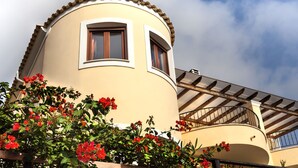 A curved building with a balcony and a window. - Your secret haven, where nature paints... close to dream sandy beaches (Kato Pavliana)