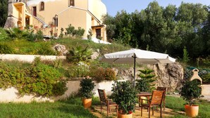 A patio with outdoor seating, a white umbrella, and potted plants. - Your secret haven, where nature paints... close to dream sandy beaches (Kato Pavliana)