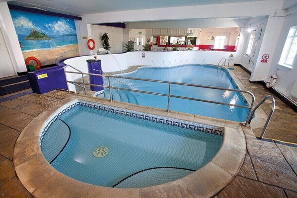 An indoor swimming pool with a mural of a beach scene, a lifebuoy, and a poolside bar area. - Stunning 2 Bedroom Stone Barn with 24" Open Plan Living Room/Kitchen/Dining (Gulval)