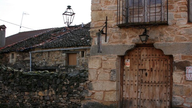 A stone building with a wooden door and a small window. - El Hogar del Fresno, charming tourist accommodation in Pedraza (Matabuena)