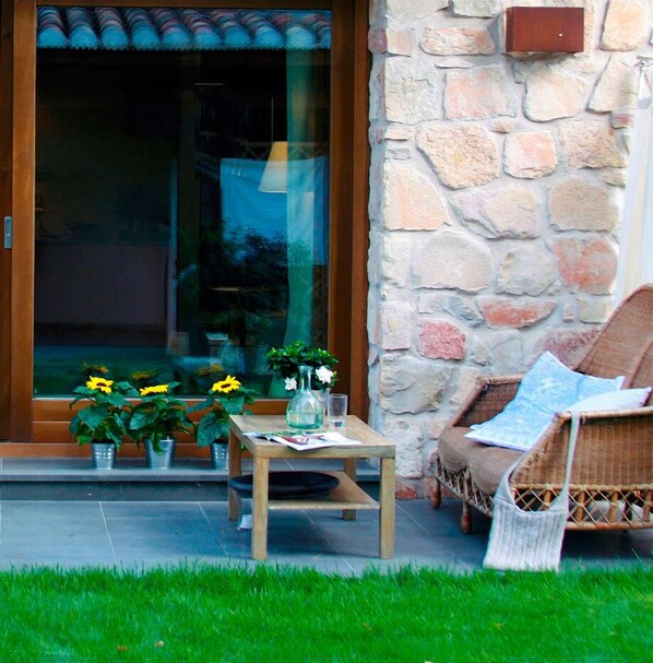 A patio area with a table, chairs, and potted plants.