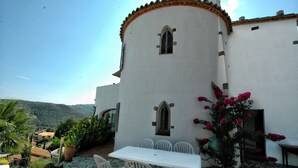 A white building with a tiled roof and a small window. There is a table and chairs outside the building. - Peaceful family villa with private pool & magnificent views, nr. perfect beaches (Calonge)