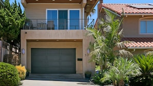 A two-story house with a garage, a balcony, and a well-maintained garden. - Carolyn's Bay View Home (San Diego)