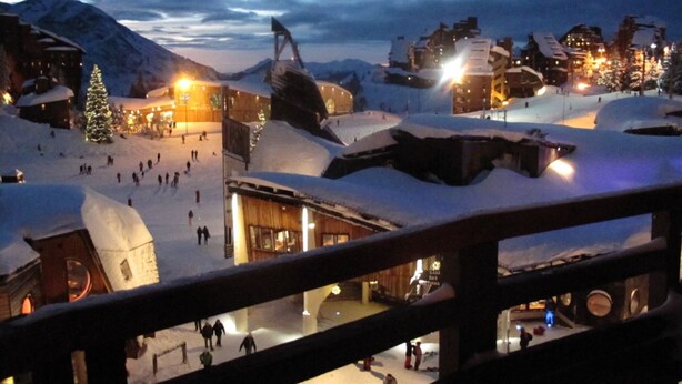 Een besneeuwde ski-resort met gebouwen en een skilift.