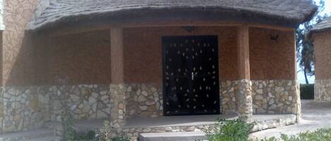 Un edificio de piedra con techo de tejas y puerta negra.