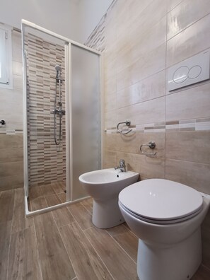Regadera, secadora de cabello, bidet, jabón 
