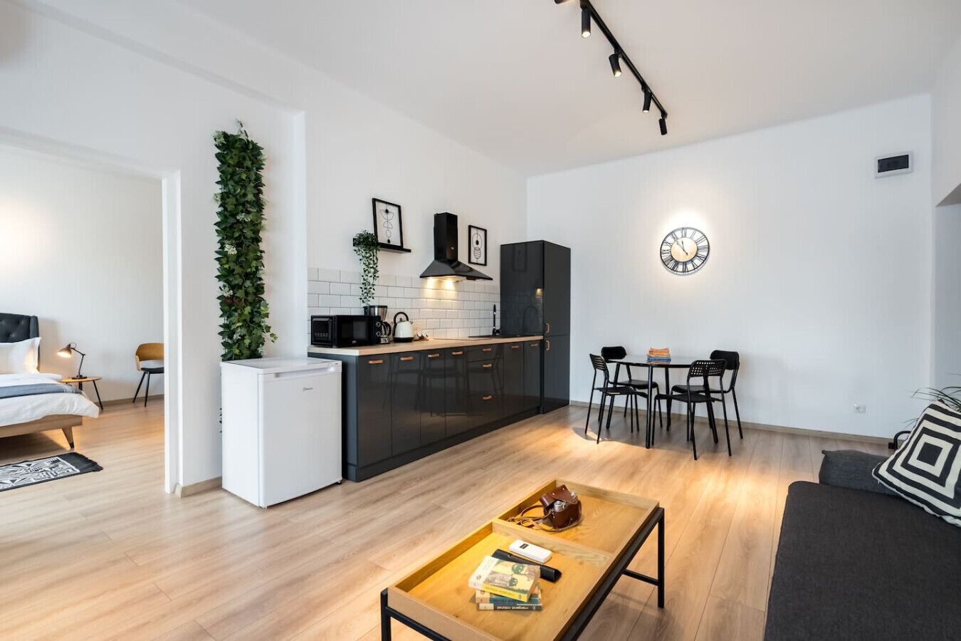A modern apartment with a kitchenette, dining area, and a living room.