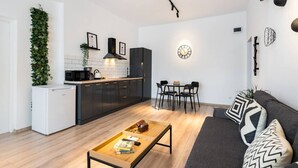 A modern living space with a kitchen, dining area, and seating area. - Esiko by MRG Apartments | Balcony | University Square | Old Town | City Centre (București)