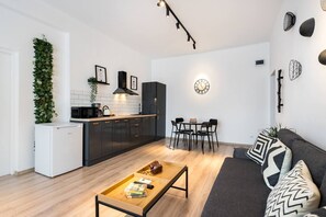 Moderni olohuone, jossa on keittiö, ruokailutila ja oleskelualue.