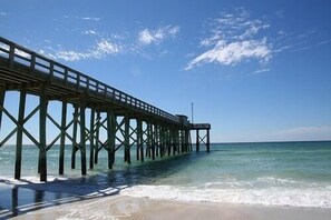 Eine Pier, die sich ins Meer erstreckt, mit blauem Himmel darüber.