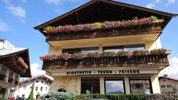 Un edificio de dos plantas con balcones decorados con macetas de flores.