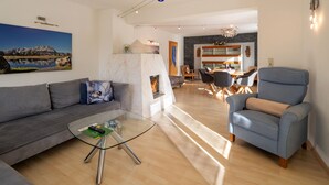 Una sala de estar moderna con una mesa de centro de vidrio, un sofá y una chimenea.