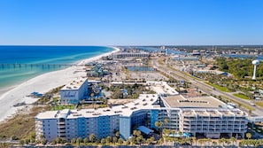 Un hotel costero con varias edificaciones, una playa y un muelle.