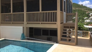 A two-story building with a pool and a balcony.