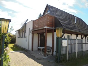 Il s’agit d’un bâtiment traditionnel doté d’un toit en pente, d’un porche en bois et d’une petite table et d’une chaise à l’extérieur.