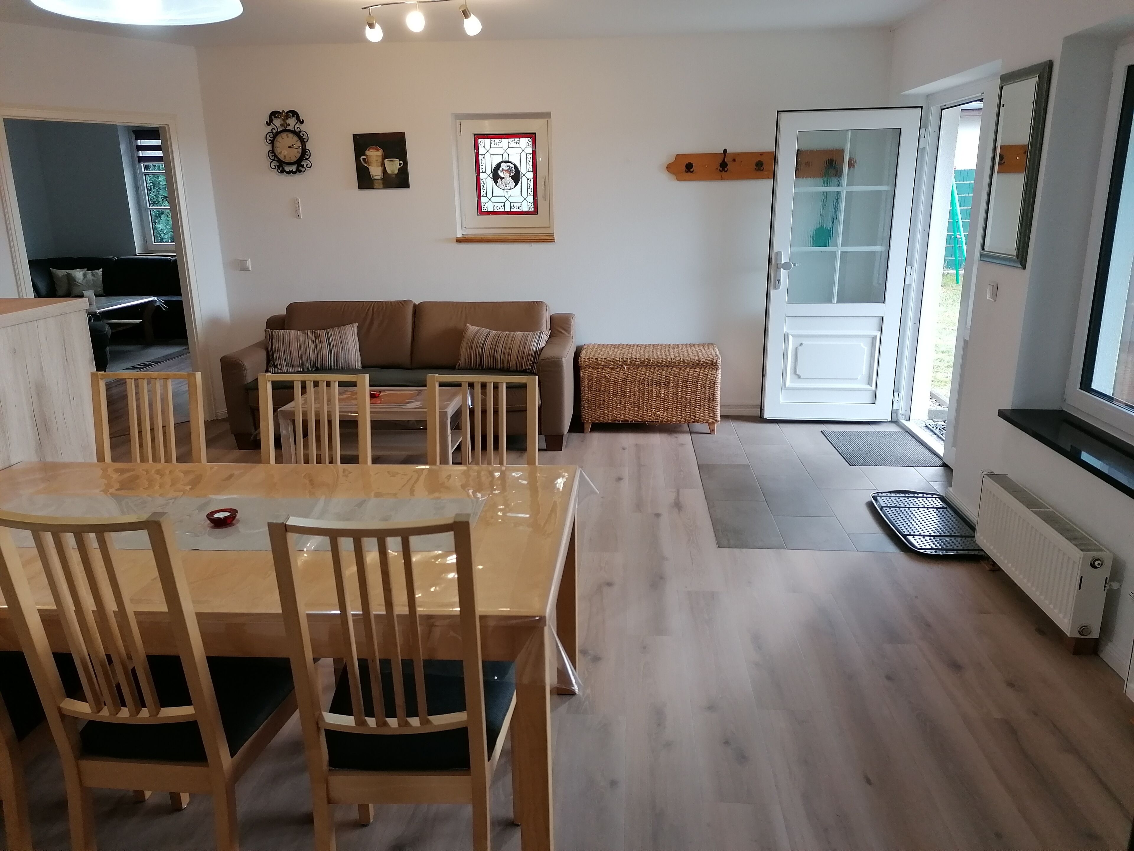 A dining area with a wooden table and chairs, a sofa, and a bench.