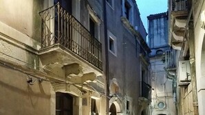 A narrow alleyway with buildings on either side, featuring arched doorways and balconies. - Fully furnished apartment, with all comforts. ALL INCLUSIVE (Siracusa)