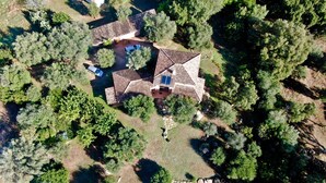Vista aerea di una casa con piscina, immersa nel verde.
