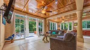 A spacious living area with a wooden ceiling, large windows, and a comfortable seating arrangement. - Casa Bamboo | 4-Bedroom Colonial Jungle Villa | Private Pool | Manuel Antonio (Manuel Antonio)
