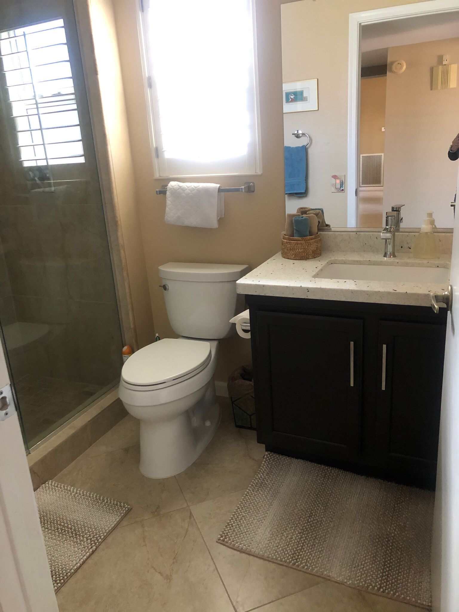 Ein Badezimmer mit Toilette, Waschbecken, Spiegel und Dusche.