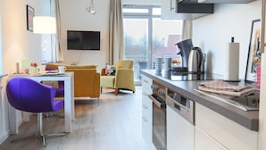 A modern kitchen with white cabinets, a built-in oven, and a microwave.